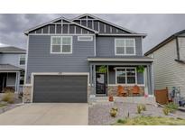 Charming two-story home with a modern gray exterior, a covered porch, and a two car garage at 635 Silver Rock Trl, Castle Rock, CO 80104