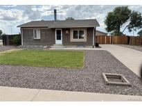 Charming brick home with a well-manicured lawn and inviting front entrance at 245 Miller Ave, Brighton, CO 80601