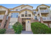 Inviting multi-story condo with brick accents, private balconies, and lush landscaping at 5726 N Genoa Way # 301, Aurora, CO 80019