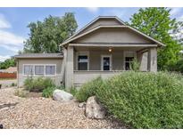 Charming single-story home with a covered porch and rock garden in the front yard at 109 W Simpson St, Lafayette, CO 80026