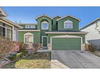 Charming green two-story home with a two-car garage and well-maintained front yard at 2116 W 101St Cir, Thornton, CO 80260