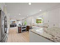 Modern kitchen featuring granite counters, stainless steel appliances, and white cabinetry at 2974 E Otero Cir, Centennial, CO 80122