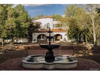 Stunning front yard with a classic fountain and grand Spanish-style home featuring a red tile roof at 3 Carriage Brook Rd, Cherry Hills Village, CO 80121