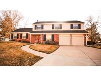 Charming two-story home with a well-maintained lawn and driveway leading to a two-car garage at 7367 S Ulster St, Centennial, CO 80112