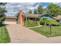 Charming home featuring a well-maintained lawn, colorful flowerbeds, and a cozy covered porch at 815 Hoyt St, Lakewood, CO 80215