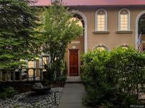 Inviting exterior view showcases the warm, neutral tones and lush, mature landscaping of this beautiful home at 425 Steele St, Denver, CO 80206