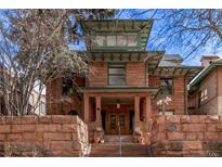 Charming three-story home featuring a brick facade, covered porch, and well-maintained landscaping at 1034 N Logan St # 2W, Denver, CO 80203