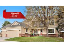 Charming two-story home with manicured lawn, mature tree, and inviting front porch at 5090 Golden Valley Trl, Castle Rock, CO 80109