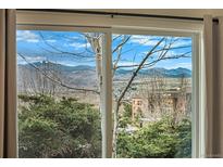 Beautiful mountain view from the window overlooking lush greenery and distant peaks on a bright, sunny day at 412 Gladiola St, Golden, CO 80401