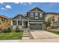 Charming two-story home boasts a well-maintained lawn and a welcoming front porch with stone accents at 10935 Valleybrook Cir, Highlands Ranch, CO 80130
