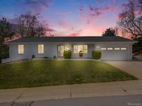 Charming, updated home with freshly painted exterior, a manicured lawn, and an attached two-car garage at 6863 S Detroit Cir, Centennial, CO 80122