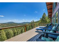 Enjoy breathtaking mountain views from this spacious deck with comfortable lounge seating at 10268 Christopher Dr, Conifer, CO 80433