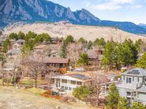 Panoramic view of neighborhood homes with the iconic Flatirons mountains in the background on a sunny day at 3380 Longwood Ave, Boulder, CO 80305