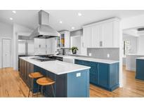 Bright kitchen featuring a center island, white cabinets, stainless steel appliances, and hardwood floors at 3380 Longwood Ave, Boulder, CO 80305