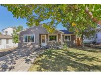 Ranch style home with a gray exterior, landscaping, and driveway at 4240 Harlan St, Wheat Ridge, CO 80033