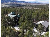 Scenic aerial view of wooded property with attractive home and detached garage at 5090 S Perry Park Rd, Sedalia, CO 80135