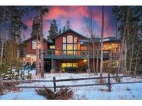 Inviting exterior view showcasing a multi-story home with a wooden deck, stone accents, and beautiful sunset backdrop at 127 Marks Ln, Breckenridge, CO 80424