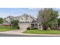 Charming two-story home featuring manicured lawn, stone accents, and a two-car garage at 20304 Vista Cir, Parker, CO 80138