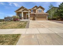 Charming two-story home boasts stone accents, a three-car garage, and well-maintained landscaping at 23559 Branston Ln, Parker, CO 80138