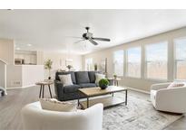 Bright living room with modern ceiling fan and comfortable seating area, with great natural light at 13915 Ivanhoe St, Thornton, CO 80602