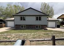 Split-level home featuring a front yard and a two-car garage on each side at 8832 Lipan St, Thornton, CO 80260