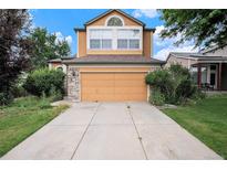 Inviting home featuring an attached two-car garage and a well-maintained lawn at 2786 S Cathay Way, Aurora, CO 80013