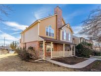 Charming two-story home with a brick facade, covered front porch, and well-maintained lawn at 317 Pheasant Run, Louisville, CO 80027