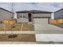 Charming single-Gathering home featuring stone accents, a two-car garage, and well-manicured front yard at 8830 Sedalia St, Commerce City, CO 80022