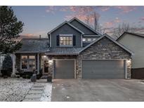 Charming two-story home featuring stone accents, gray siding, and a spacious two-car garage at 10262 S Royal Eagle Ln, Highlands Ranch, CO 80129