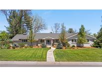 Charming single story home with a tidy lawn, mature trees, and a welcoming walkway to the front door at 21 Fairway Ln, Littleton, CO 80123