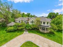 Stunning two-story home with beautifully landscaped grounds, circular driveway, and inviting architecture at 980 E Tufts Ave, Cherry Hills Village, CO 80113