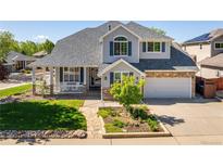 Charming two-story home featuring a stone facade, covered porch, and well-manicured lawn at 1996 Clipper Dr, Lafayette, CO 80026