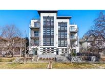 Modern condo building with sleek design, balconies, and professional landscaping against a bright blue sky at 1738 N Franklin St # 2B, Denver, CO 80218