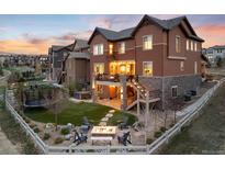 Backyard featuring an outdoor fire pit, trampoline, seating area and lush lawn perfect for entertaining at 10580 Greycliffe Dr, Highlands Ranch, CO 80126