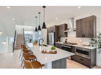 Modern kitchen boasts a large island, stainless steel appliances, and sleek wood cabinetry at 10163 W 38Th Ave, Wheat Ridge, CO 80033