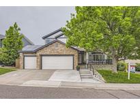 Charming home featuring stone accents, three-car garage, and inviting curb appeal at 8657 Aberdeen Cir, Highlands Ranch, CO 80130