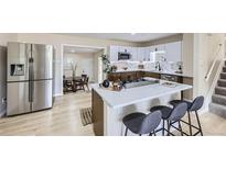 Modern kitchen with stainless steel appliances, white cabinets and quartz counters with center island cooktop at 1880 E 81St Pl, Denver, CO 80229