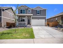 Charming two-story home with a well-maintained lawn and a two-car garage at 760 N Allium St, Watkins, CO 80137