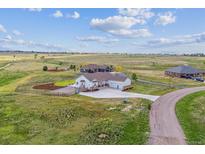 Expansive home with a three-car garage nestled in a vast, open landscape with a long drive at 527 Antelope E Dr, Bennett, CO 80102