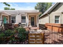 Charming single-story home featuring a cozy front porch and landscaped garden with a decorative fence at 3647 Jason St, Denver, CO 80211
