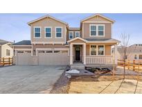 Charming two-story home with a three car garage, covered porch, and neutral tan and beige color palette at 25076 E 41St Ave, Aurora, CO 80019