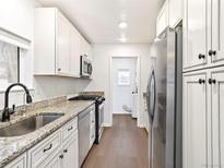 Well-lit kitchen featuring stainless steel appliances, granite countertops, and white cabinets at 1213 Jamaica St, Aurora, CO 80010