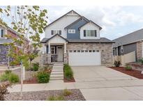 Charming two-story home featuring a stone facade, inviting entrance, and a well-maintained landscaped front yard at 4444 N Picadilly Ct, Aurora, CO 80019