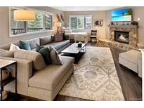 Comfortable living room features large sectional sofa, stone fireplace, and mountain views at 290 Broken Lance Dr # B104, Breckenridge, CO 80424