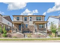 Modern townhouse exterior with stone accents, covered porch, and well-maintained landscaping at 21761 E 7Th Ave, Aurora, CO 80018