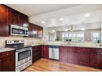 A kitchen featuring stainless appliances, granite countertops and dark wood cabinets at 1095 W 69Th Ave, Denver, CO 80221