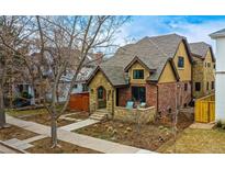 Charming brick and stone two-story home featuring a cozy front porch and well-maintained landscaping at 519 S Gaylord St, Denver, CO 80209