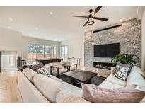 Open living room with hardwood floors, a fireplace with tv, a billiard table, and modern design at 519 S Gaylord St, Denver, CO 80209