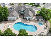 Aerial view of a large, kidney-shaped community pool with a hot tub and ample lounge seating for residents and guests at 3250 E 103Rd Pl # 805, Thornton, CO 80229