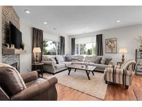 Bright living room features hardwood floors, fireplace, and large windows with backyard views at 10152 Bluffmont Ln, Lone Tree, CO 80124
